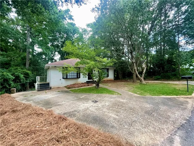 Mature trees and a welcoming driveway frame this private suburban retreat.