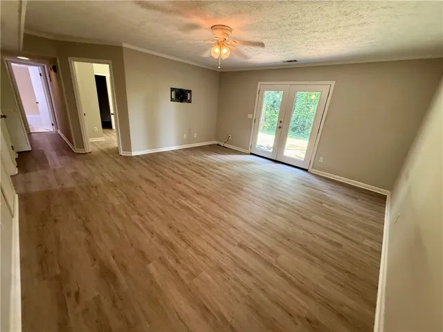 Hardwood-style flooring extends through this generously proportioned living space with a double door entry.