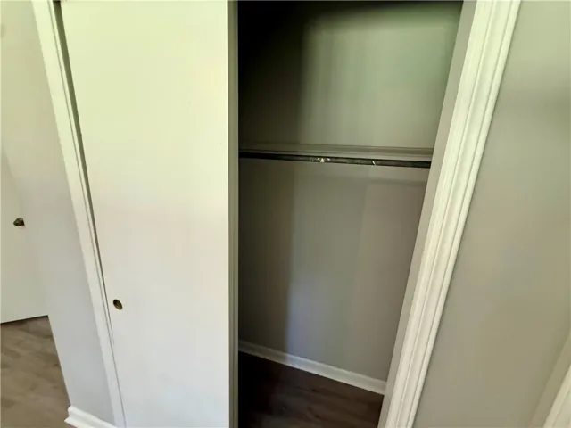 Functional wardrobe featuring a hanging rod and laminate flooring, ready for personalization.