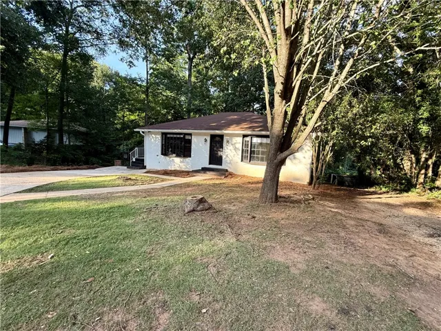 A classic ranch home nestled among mature trees offers privacy and a peaceful setting.