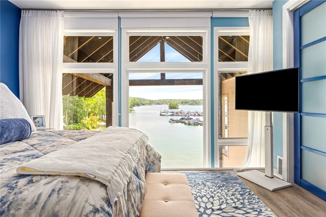 Uninterrupted waterfront views provide a tranquil escape from this inviting bedroom.
