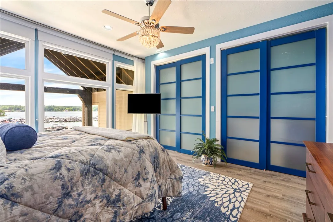 Floor-to-ceiling windows offer panoramic lake views from this serene primary suite.