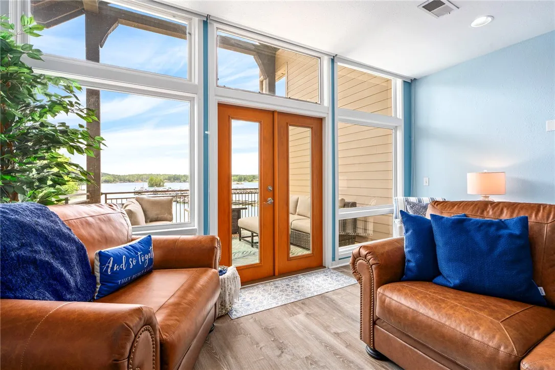 Floor-to-ceiling glass doors and windows frame panoramic water views from this inviting living space.
