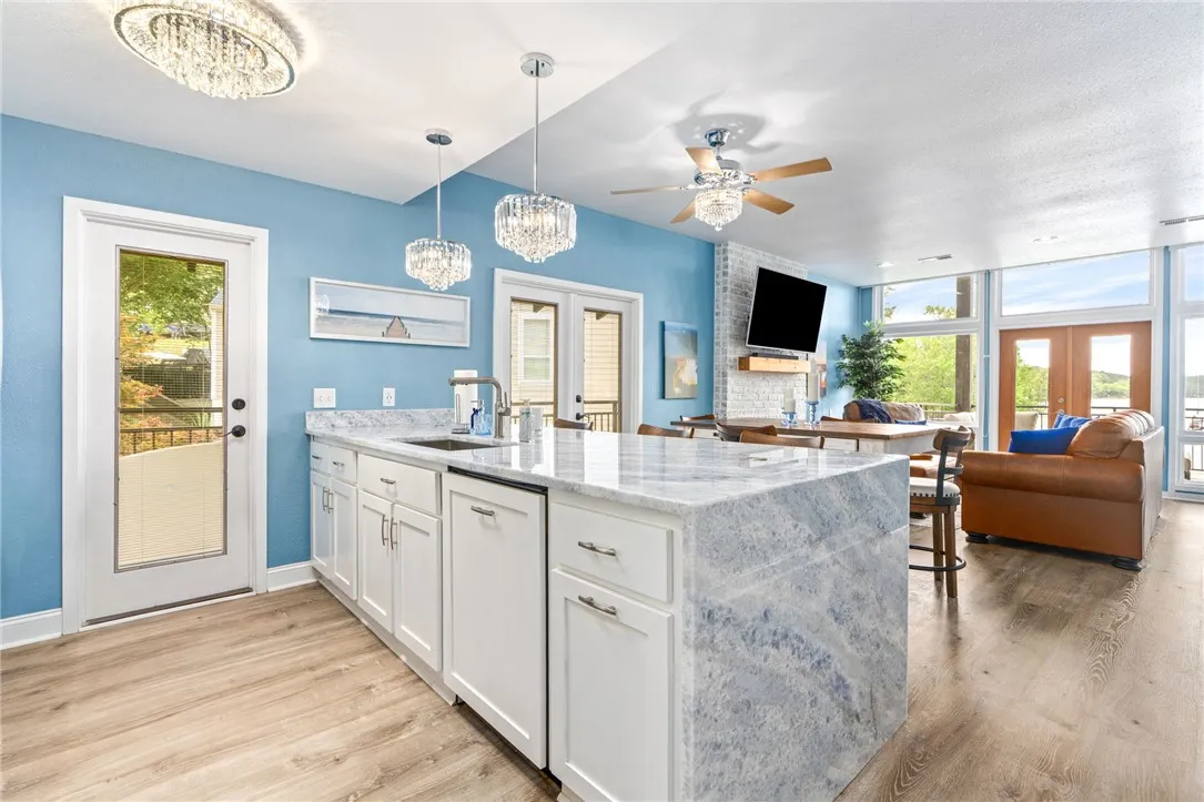 A well-appointed kitchen island with elegant stone counters seamlessly flows into a spacious living area with outdoor access.