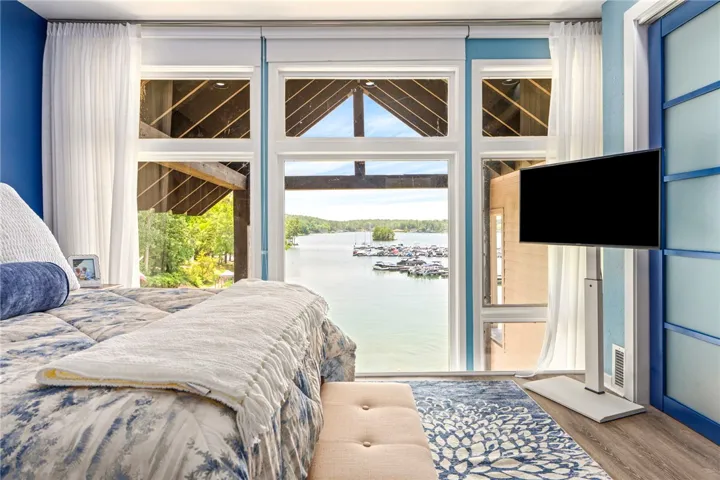Uninterrupted waterfront views provide a tranquil escape from this inviting bedroom.