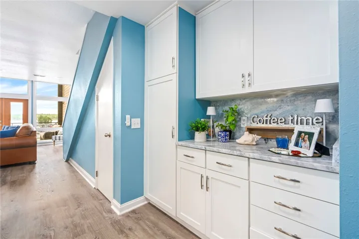 Custom cabinetry and durable flooring create a functional space with a charming dry bar.