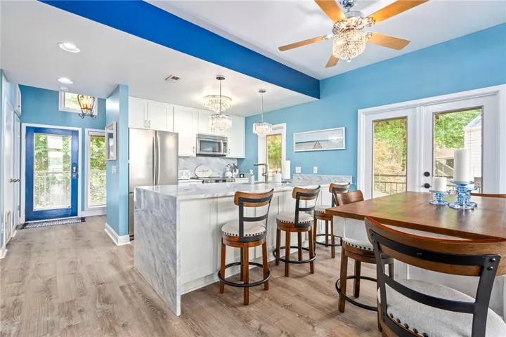 A vibrant kitchen features a breakfast bar, stainless steel appliances, and outdoor access through glass doors.