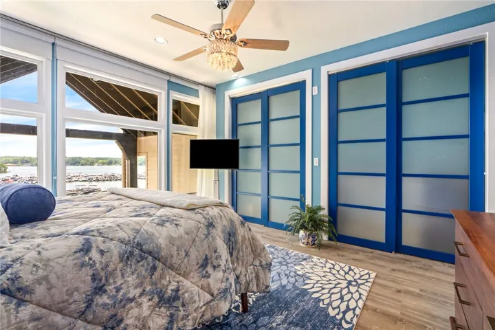 Floor-to-ceiling windows offer panoramic lake views from this serene primary suite.