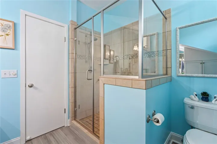 A well-appointed bathroom featuring a tiled walk-in shower and light blue walls.