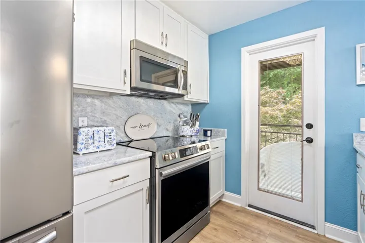 A compact culinary space features stainless steel appliances and crisp white cabinetry.