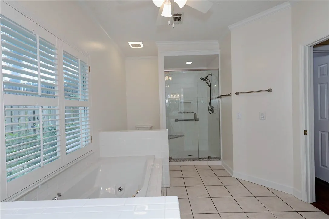 Indulge in a primary bathroom retreat featuring a luxurious soaking tub and a glass-enclosed shower.
