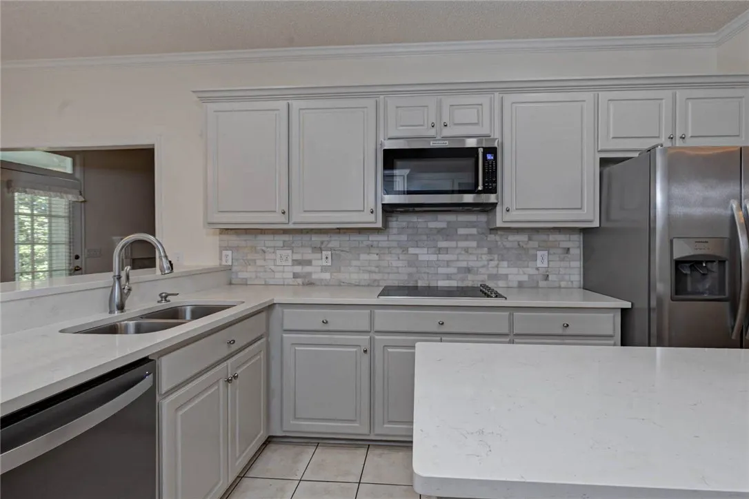 Culinary delights await in this modern kitchen featuring a sleek cooktop and ample counter space.