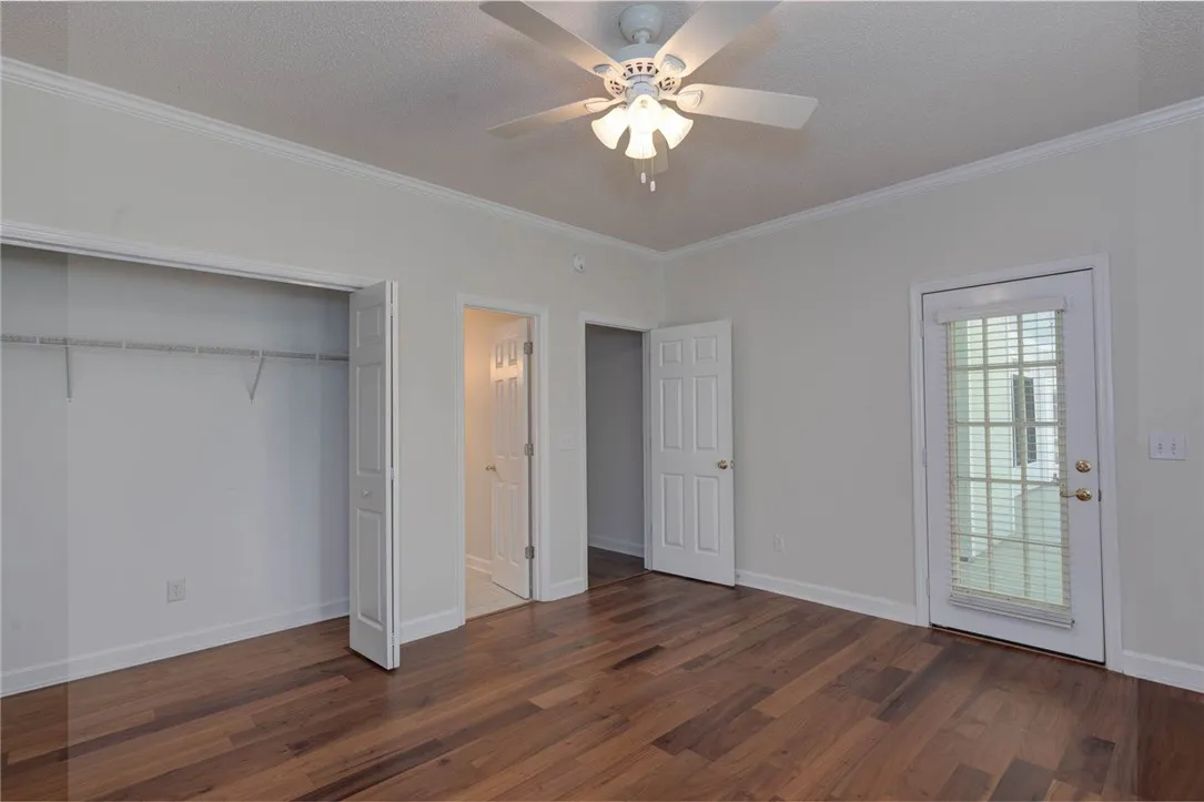 Hardwood floors and bright doors complete this well-appointed bedroom space.