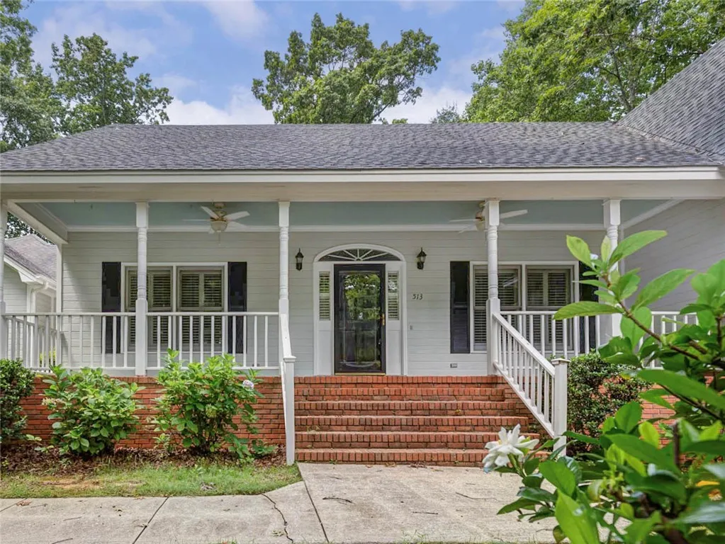 A charming front porch with brick steps invites you into this welcoming residence.