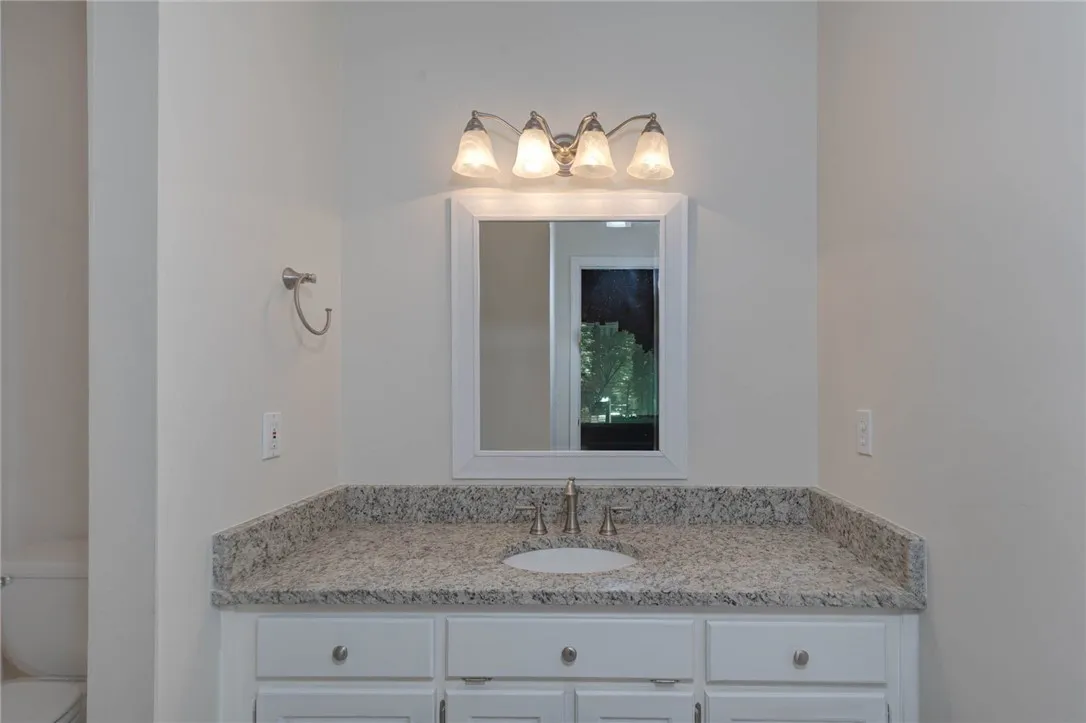 A well-appointed bathroom vanity features a stone counter and elegant lighting.