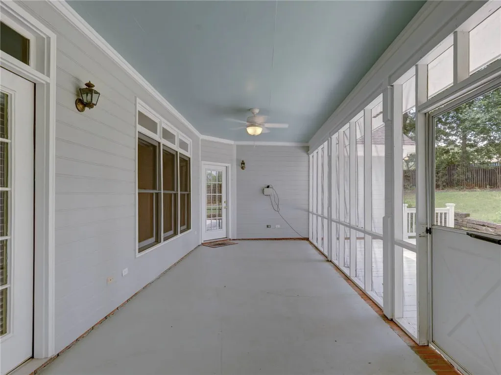 A tranquil screened porch offers seamless outdoor living, complete with a gentle breeze from the ceiling fan.