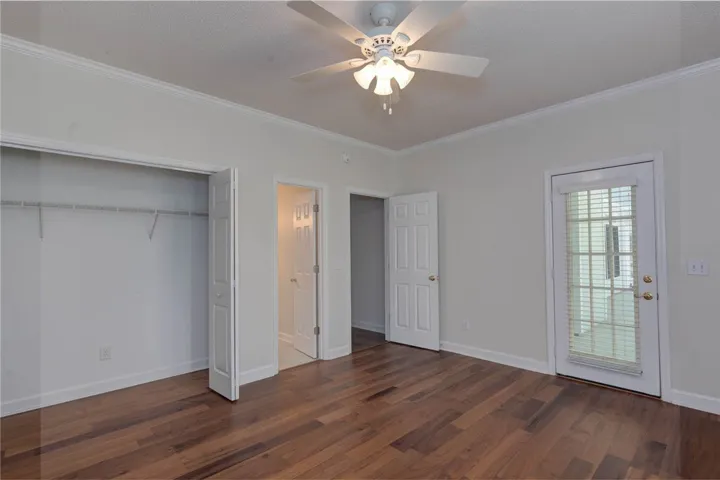 Hardwood floors and bright doors complete this well-appointed bedroom space.