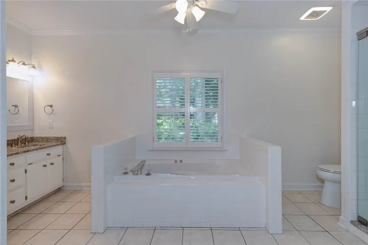 Indulge in relaxation within this primary bathroom, featuring a deep soaking tub and dual vanity.