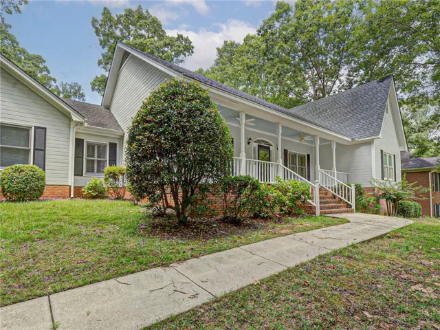 A graceful front porch extends a warm welcome, enhancing the home's inviting curb appeal.