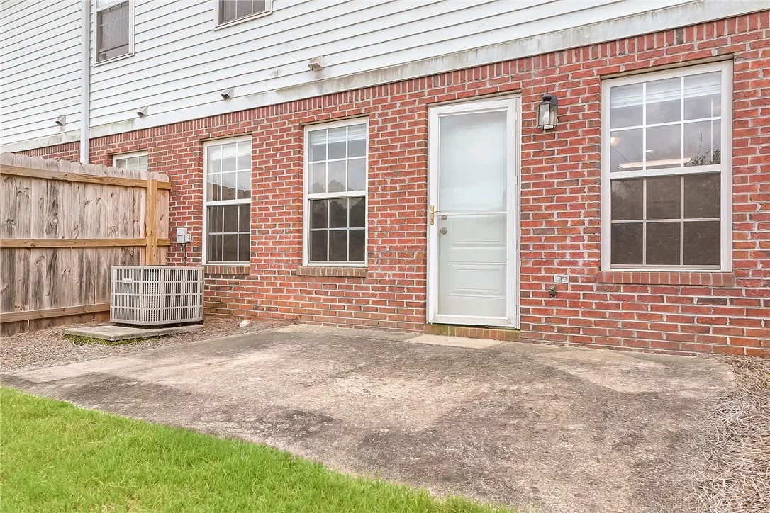 A private concrete patio extends from the home's brick and siding facade, offering a versatile outdoor space.