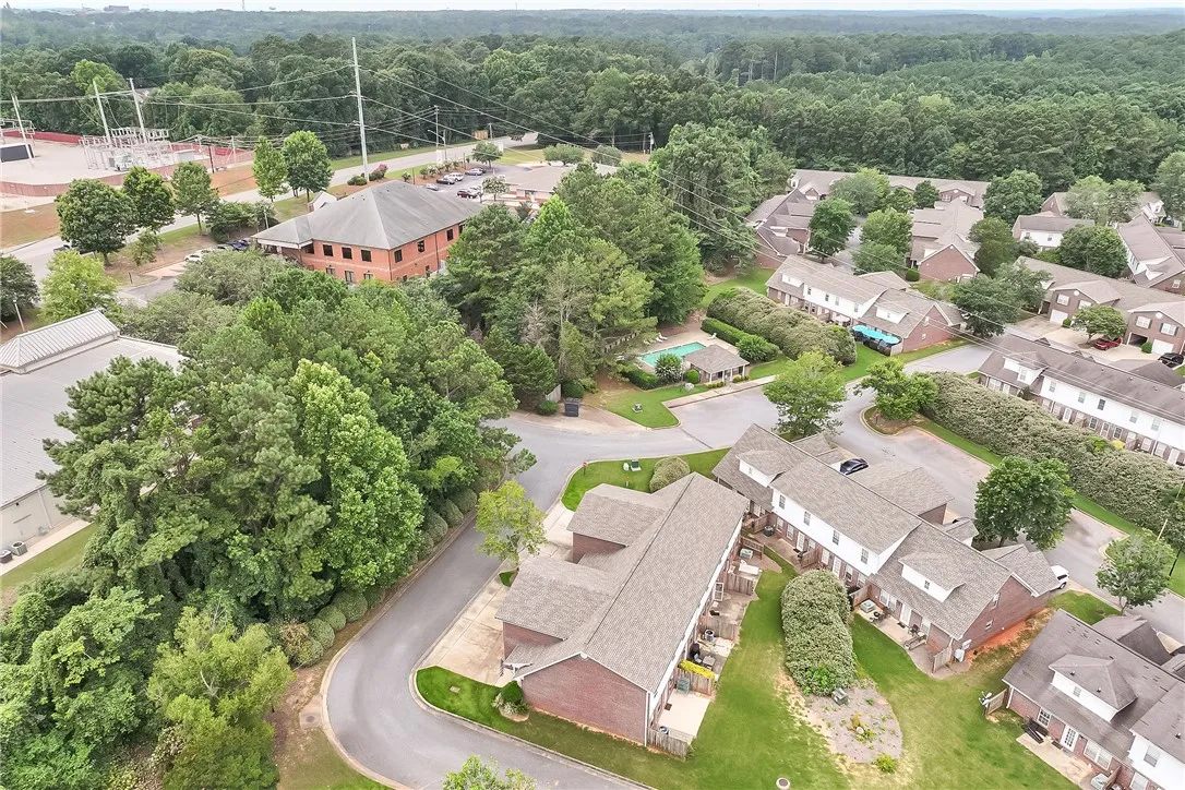 Discover a tranquil community with a refreshing pool, nestled among mature trees and winding roads.