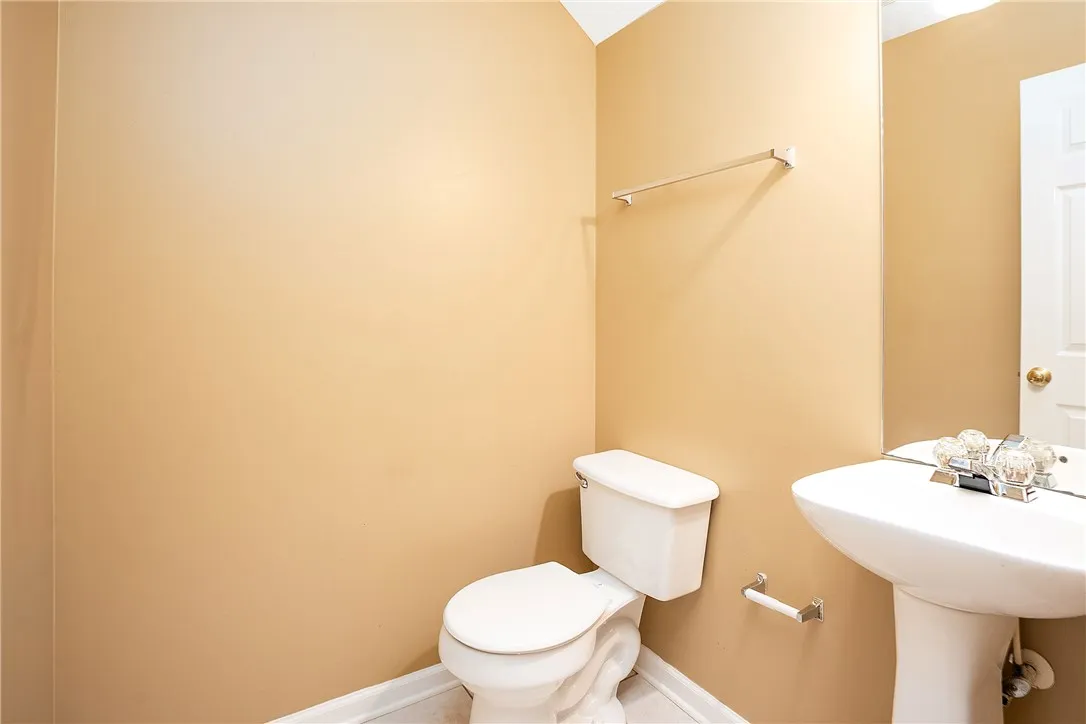 A compact and functional bathroom space featuring a white pedestal sink and toilet.