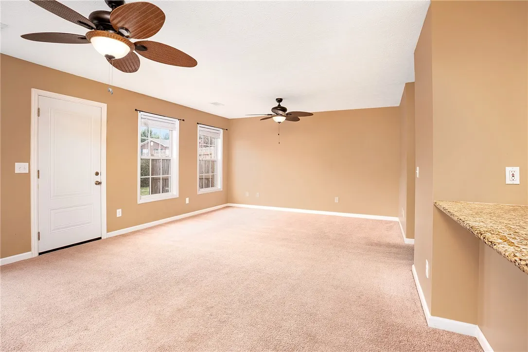 An inviting open-concept living space awaits with neutral carpet and ample natural light.