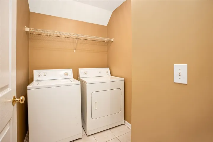 Functional utility room offering convenient laundry appliances and practical wire shelving.