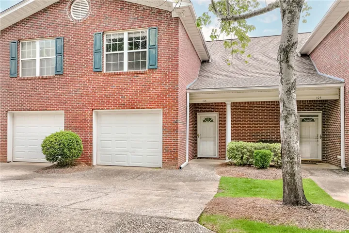 A classic brick exterior presents a welcoming façade, complemented by mature landscaping.
