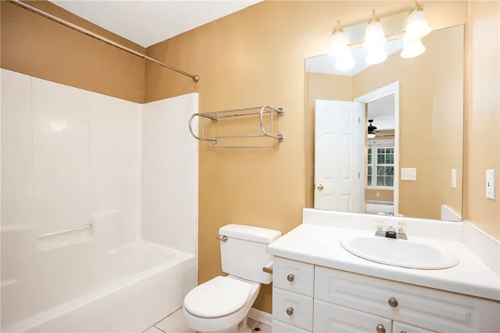 A pristine bathroom features a classic shower-tub combo and a functional vanity with ample storage.