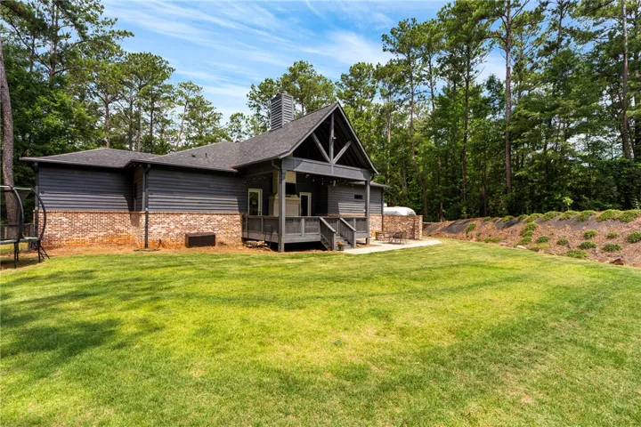 A deep backyard with a patio and deck provides ample outdoor living space.