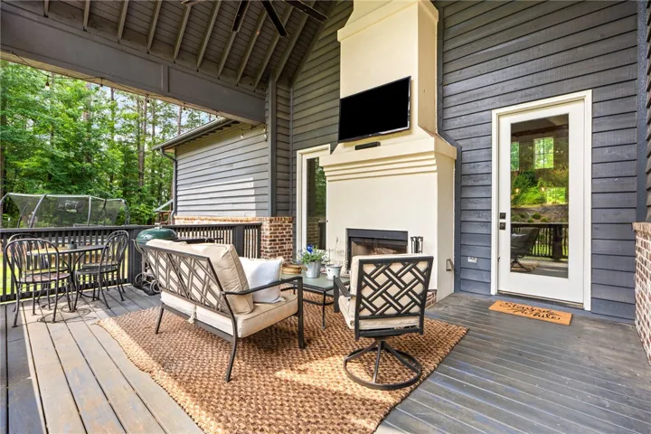 An inviting outdoor living space features a cozy fireplace and ample room for relaxation and entertainment.