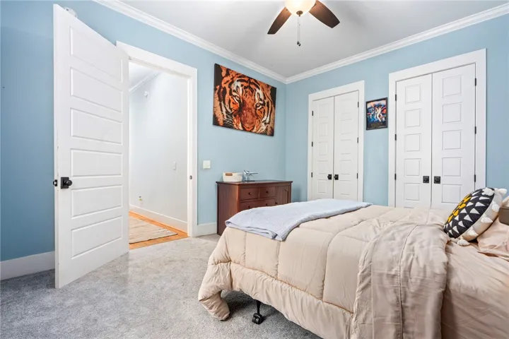 A comforting bedroom space features soft gray carpeting and multiple paneled doors.
