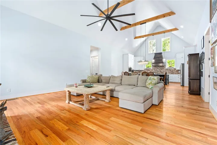 Vast, open-concept living area with soaring vaulted ceilings and rich hardwood floors.