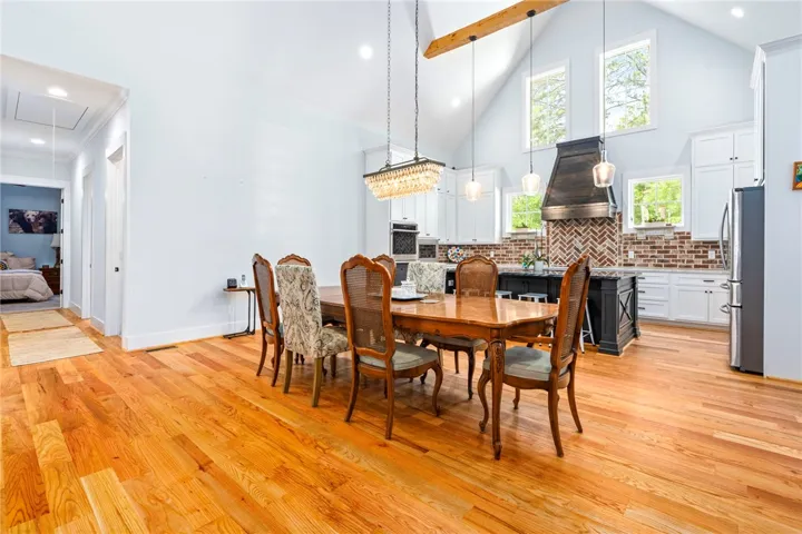 Hardwood floors flow through this open-concept dining area and kitchen with vaulted ceilings.