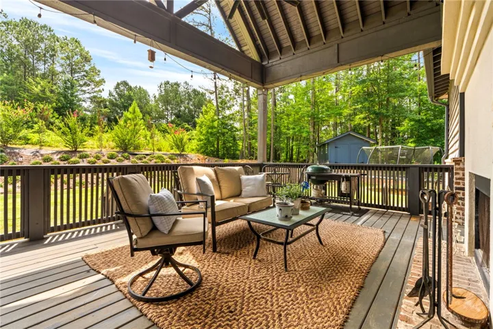An inviting outdoor living space features a covered patio with serene views of surrounding greenery.