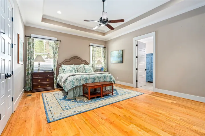 A restful retreat with gleaming hardwood floors and an elegant tray ceiling.