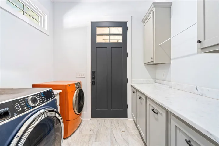 Functional laundry room equipped with modern appliances and ample counter space for daily tasks.
