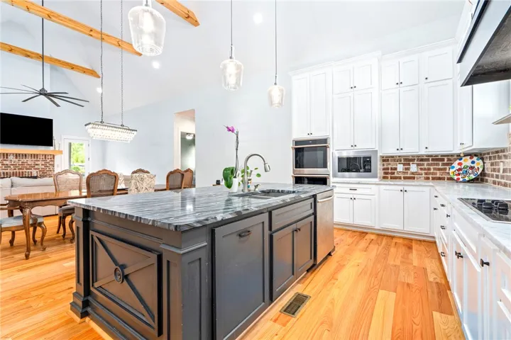A well-appointed kitchen features a grand island, abundant cabinetry, and a cozy adjacent dining space.