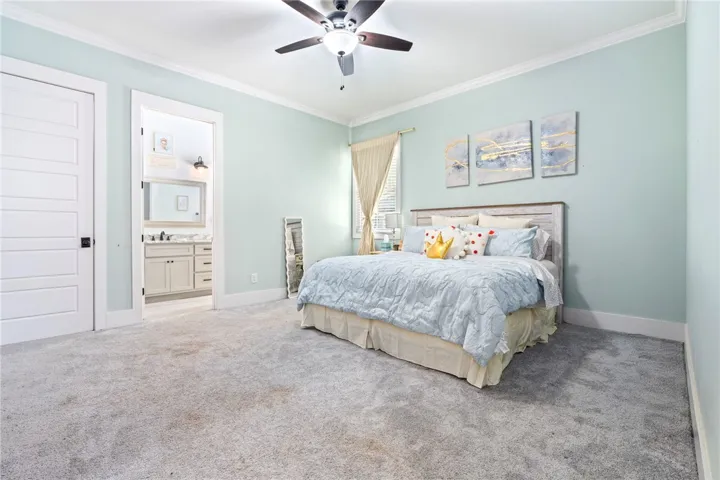 A comforting bedroom oasis with plush carpet flooring and a private attached bath.