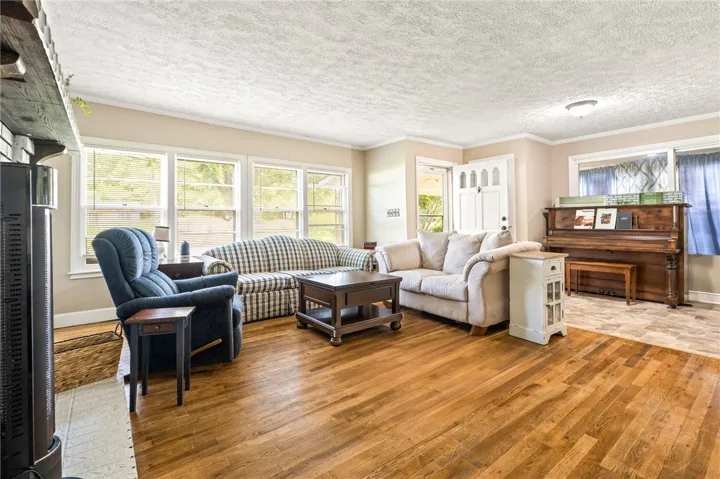 Hardwood flooring extends through this comfortable living space, offering abundant natural illumination from a wall of windows.