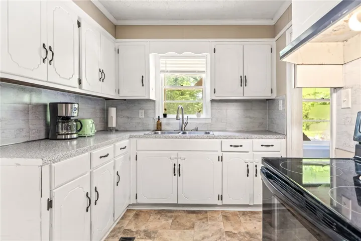 A well-lit kitchen featuring classic white cabinetry and practical counter space, perfect for everyday living.