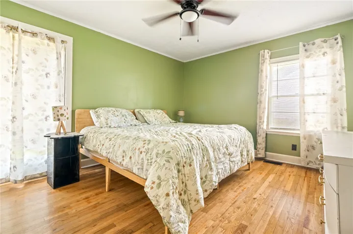 Hardwood floors and ample natural light define this cozy bedroom retreat.