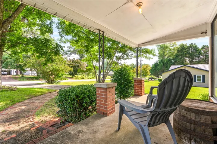 Relax on this inviting porch with brick columns and enjoy the surrounding natural greenery.