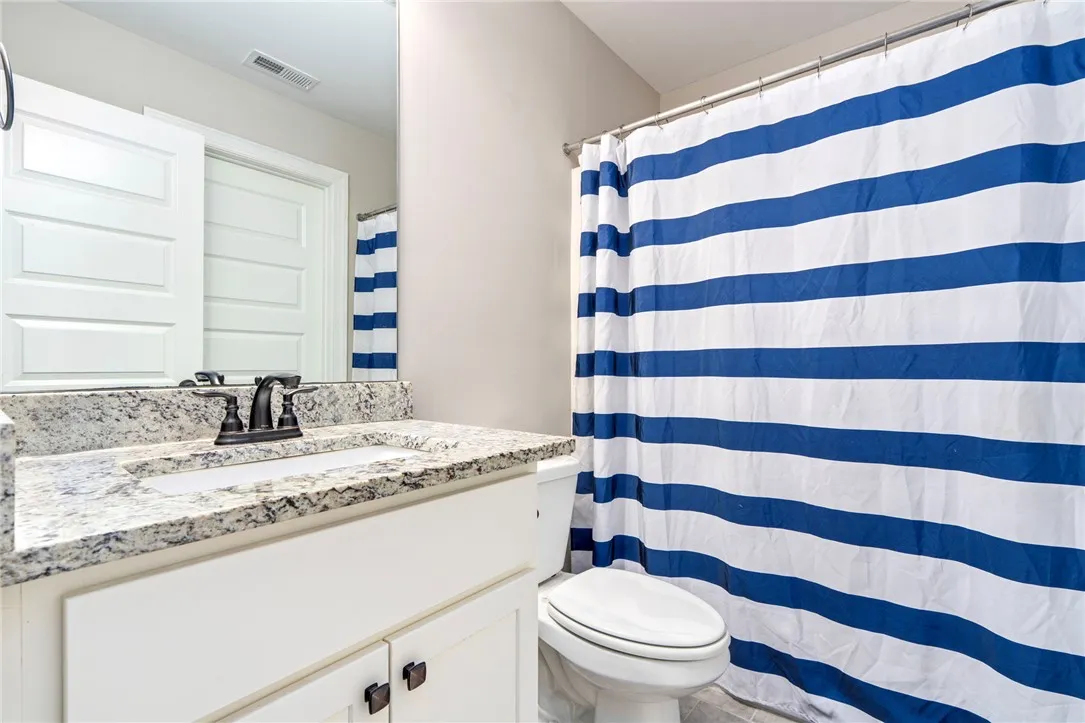A well-appointed bathroom with a spacious vanity, framed mirror, and a full shower-tub combination.