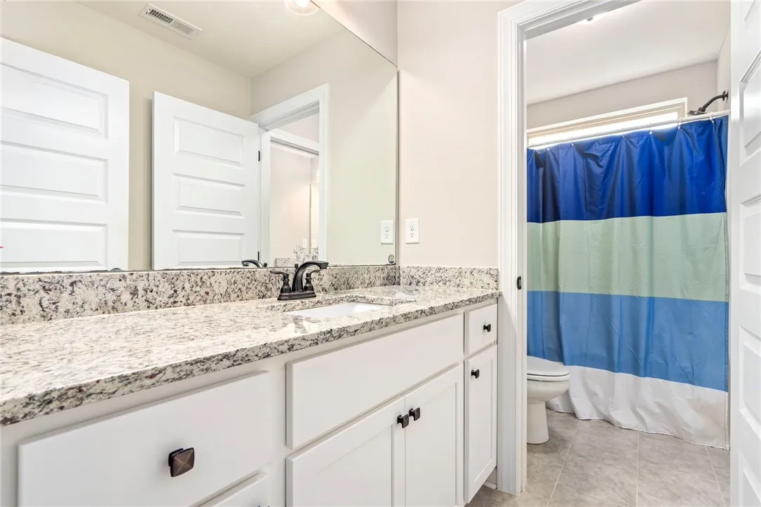 Granite counters and bright cabinetry define this well-appointed bathroom vanity.