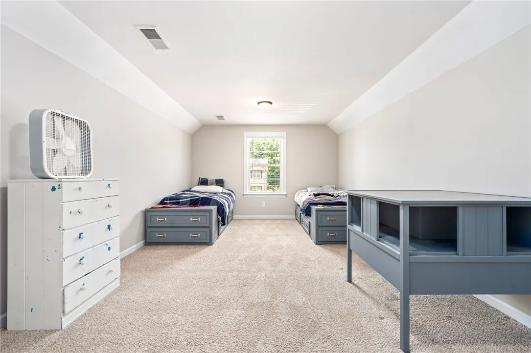 A window bathes this carpeted bedroom in soft, natural light, perfect for restful slumber.
