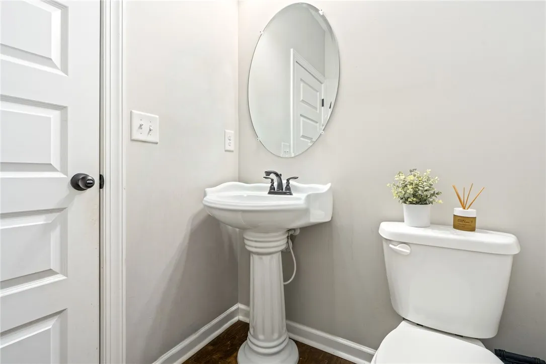 A well-appointed powder room features a classic pedestal sink and an oval mirror.