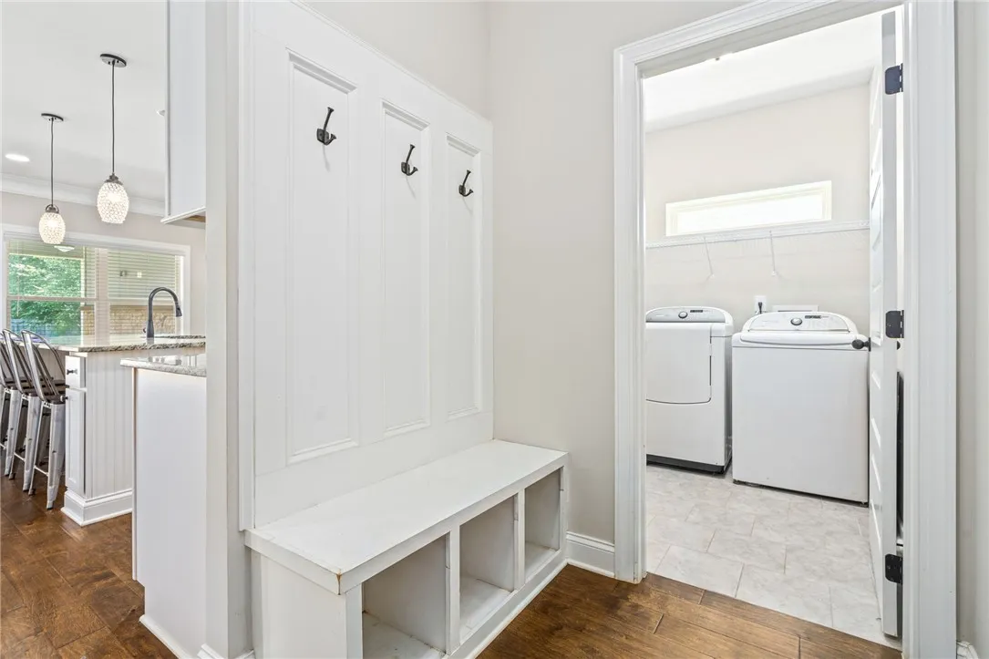 Functional entryway drop zone with integrated storage for daily essentials, conveniently adjacent to a dedicated laundry space.