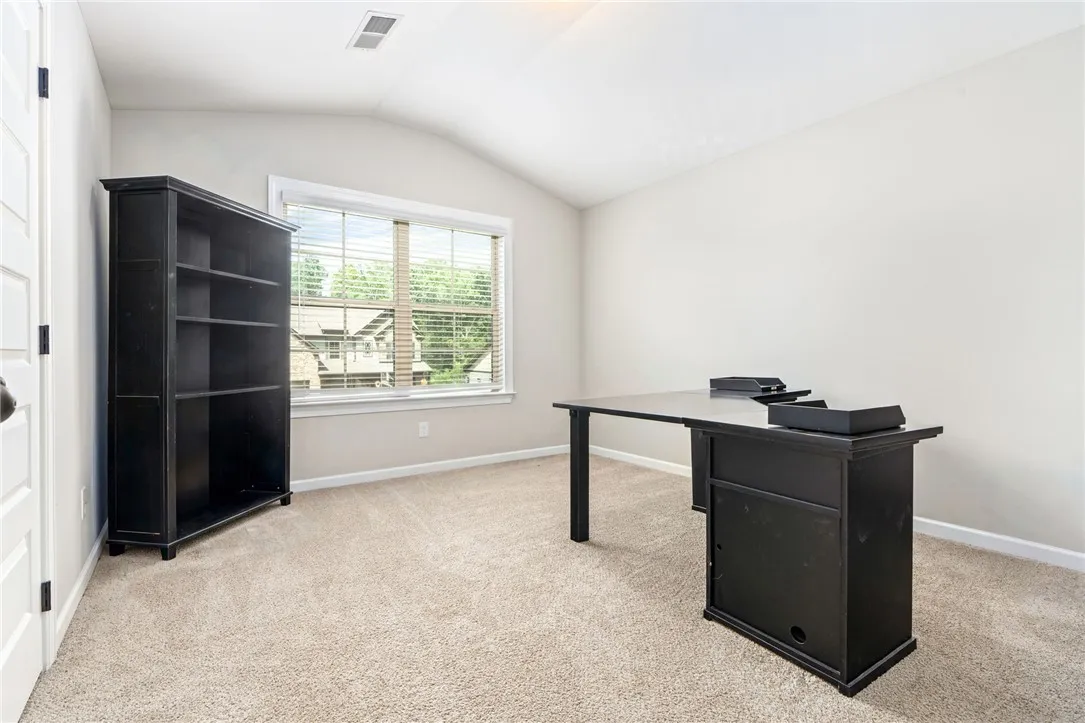 A quiet retreat with a vaulted ceiling and ample natural light, ideal for a home office.